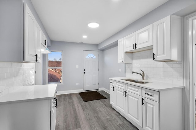 kitchen featuring tasteful backsplash, sink, white cabinets, and light wood-type flooring
