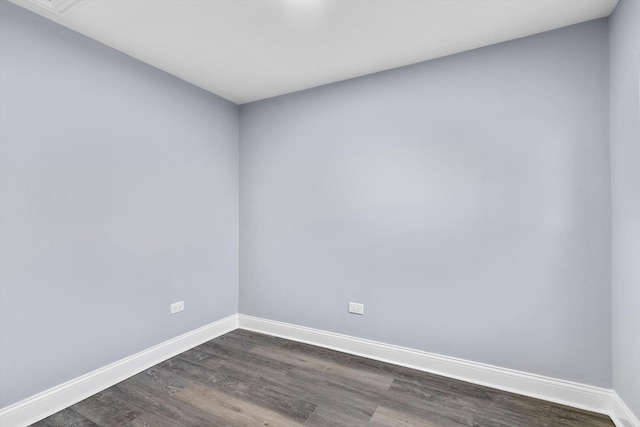unfurnished room with dark wood-type flooring