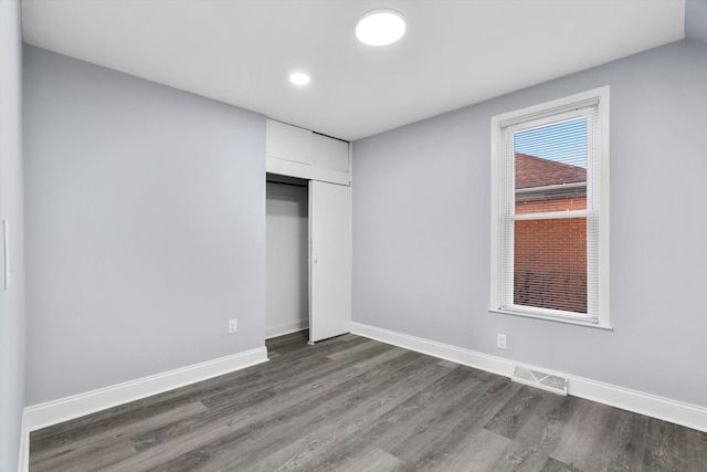 unfurnished bedroom featuring a closet and dark hardwood / wood-style floors