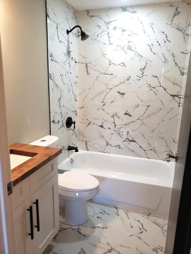 full bathroom featuring tiled shower / bath combo, vanity, and toilet