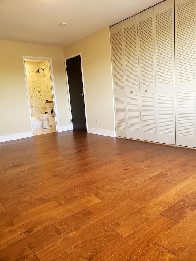 unfurnished bedroom with a closet and wood-type flooring