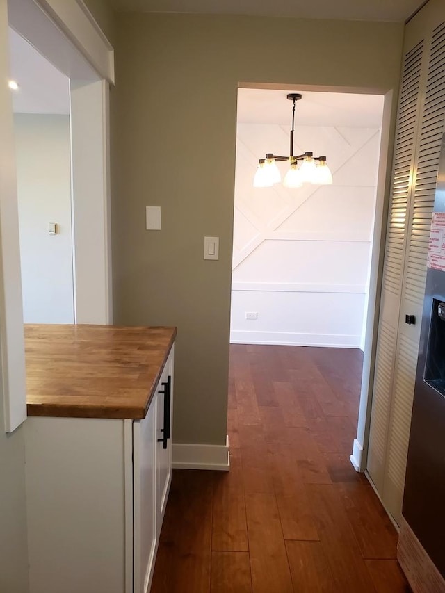 corridor featuring dark hardwood / wood-style flooring and a notable chandelier