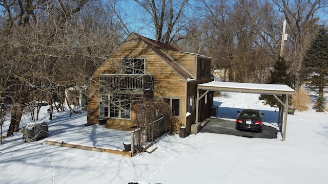 snow covered property with a carport