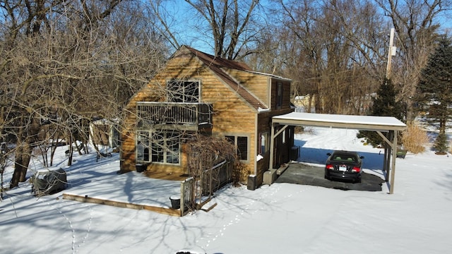 snow covered property featuring a carport