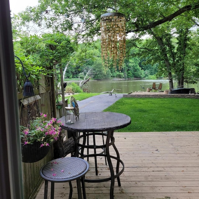 exterior space with a lawn and a deck with water view