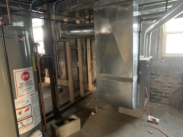utility room featuring heating unit and gas water heater