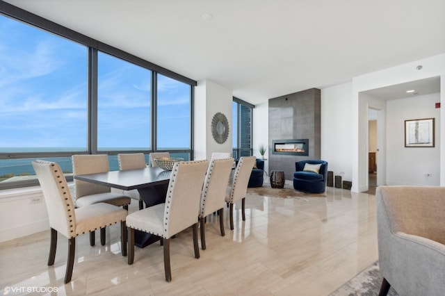 dining area with a water view and a large fireplace