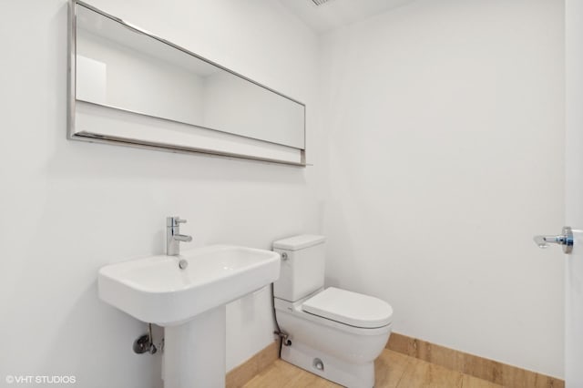 bathroom with hardwood / wood-style floors, sink, and toilet