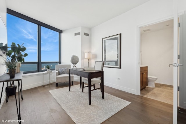 office area with a water view and hardwood / wood-style flooring