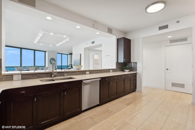 kitchen featuring dark brown cabinetry, dishwasher, sink, and backsplash