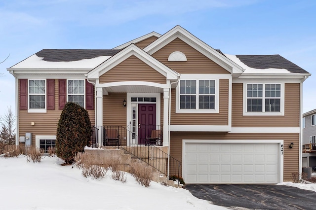 split foyer home with aphalt driveway and a garage