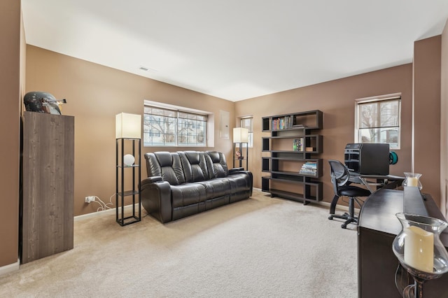 carpeted home office featuring a healthy amount of sunlight, visible vents, and baseboards