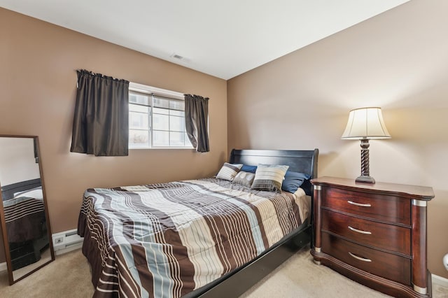 bedroom featuring light carpet, baseboard heating, and visible vents