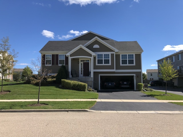 raised ranch with an attached garage, driveway, and a front yard