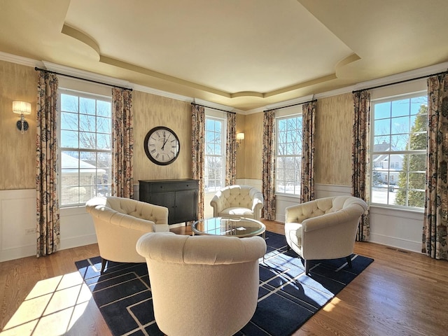 sitting room with a raised ceiling, ornamental molding, and hardwood / wood-style floors