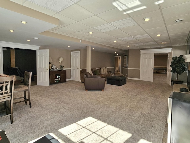 carpeted living room with a drop ceiling