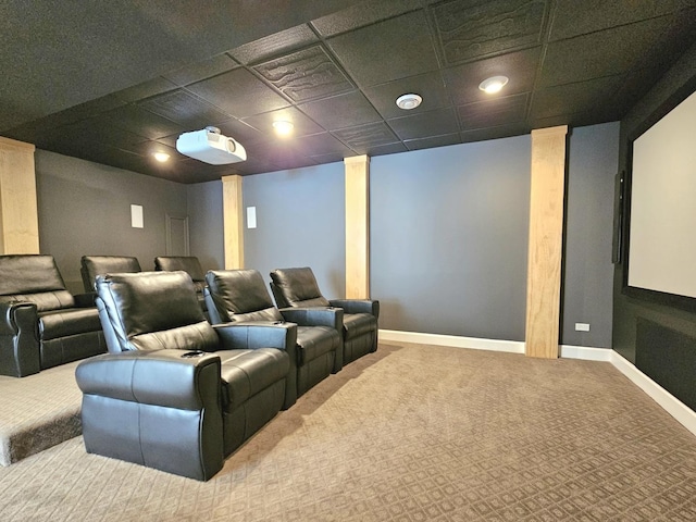 carpeted cinema room featuring a paneled ceiling