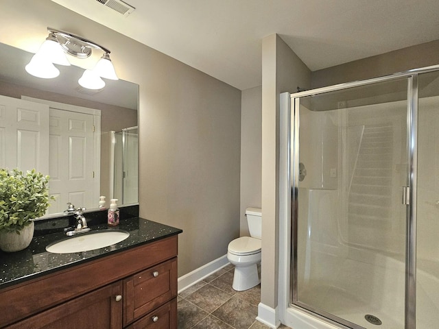 bathroom featuring vanity, a shower with shower door, tile patterned floors, and toilet