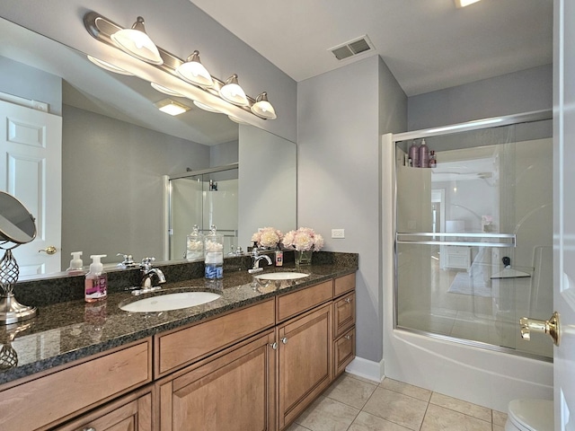 full bathroom featuring tile patterned flooring, vanity, enclosed tub / shower combo, and toilet