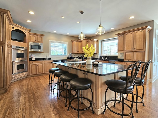 kitchen featuring hanging light fixtures, plenty of natural light, a center island, and appliances with stainless steel finishes