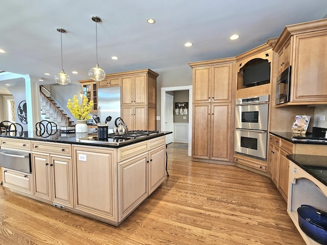 kitchen with decorative columns, built in appliances, light hardwood / wood-style floors, decorative light fixtures, and light brown cabinets