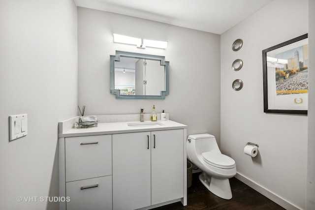 bathroom with vanity, toilet, and hardwood / wood-style floors