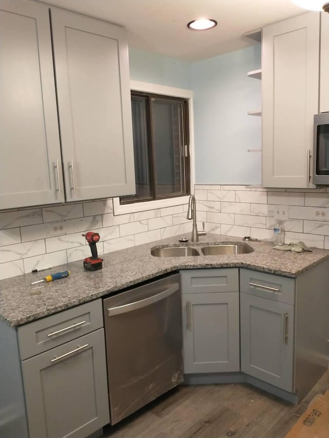 kitchen featuring appliances with stainless steel finishes, sink, dark stone countertops, and gray cabinetry