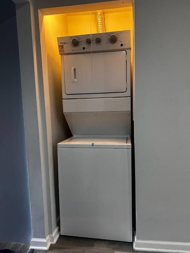 clothes washing area with stacked washer / drying machine and hardwood / wood-style floors