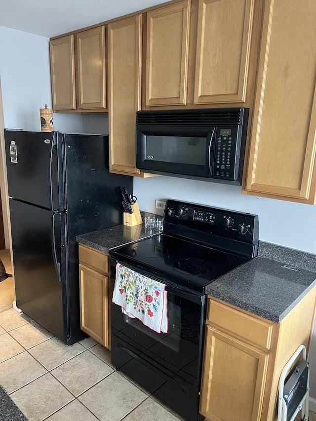 kitchen with light tile patterned flooring and black appliances