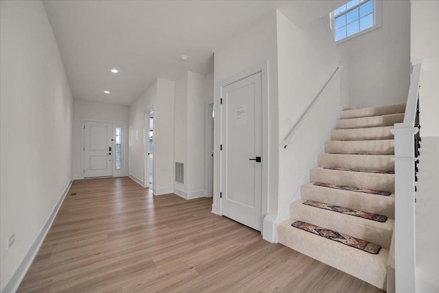 foyer with light wood-style flooring, recessed lighting, visible vents, baseboards, and stairs