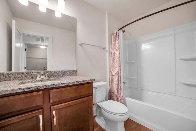 full bathroom featuring hardwood / wood-style flooring, shower / bath combination with curtain, vanity, and toilet