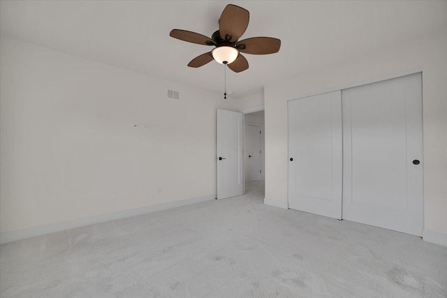 unfurnished bedroom featuring a closet, light carpet, and ceiling fan