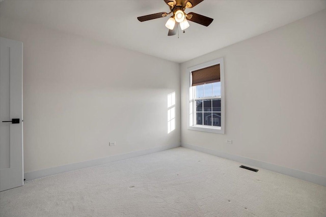 carpeted spare room featuring ceiling fan