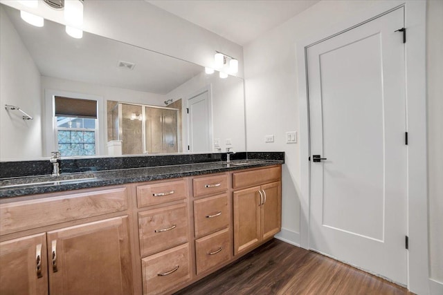 bathroom featuring vanity, wood-type flooring, and a shower with shower door