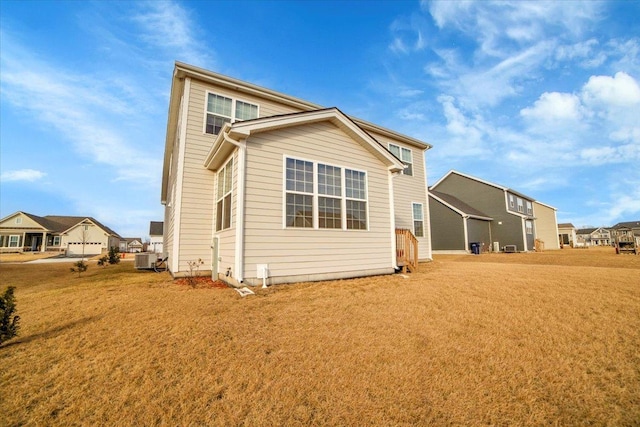 rear view of property with a yard and cooling unit