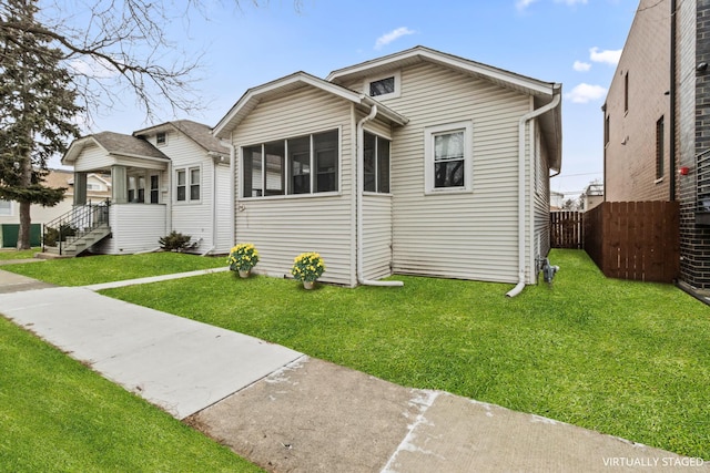 view of front of home with a front yard and fence