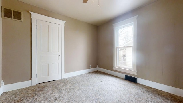 unfurnished room featuring ceiling fan and carpet flooring