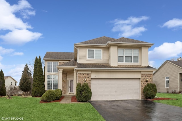 traditional-style home with aphalt driveway, brick siding, an attached garage, and a front yard