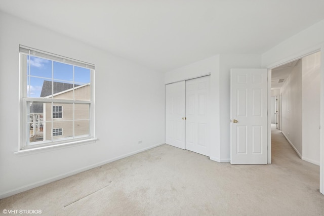 unfurnished bedroom featuring a closet, baseboards, and carpet