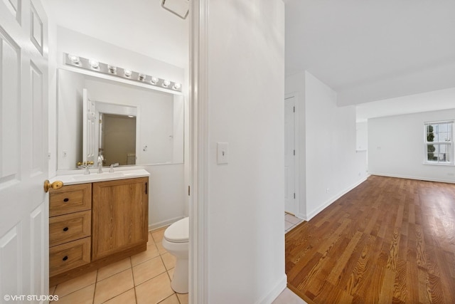 bathroom featuring tile patterned flooring, toilet, vanity, and baseboards