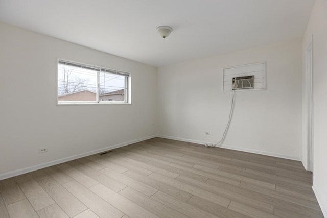 spare room featuring light hardwood / wood-style floors and a wall mounted AC