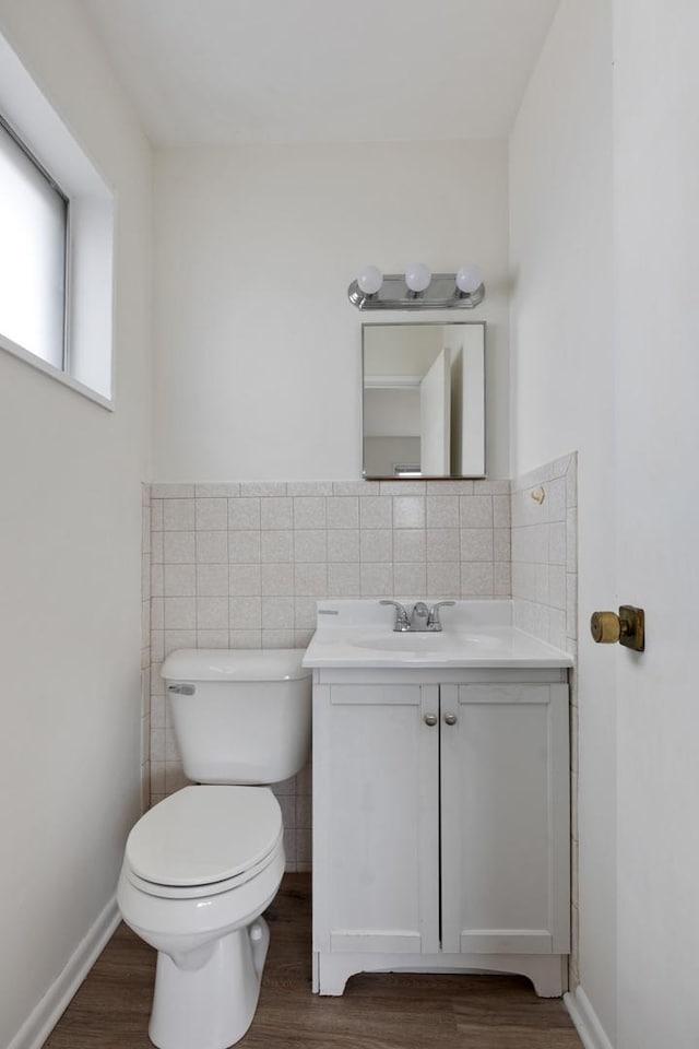 bathroom featuring vanity, toilet, hardwood / wood-style floors, and tile walls