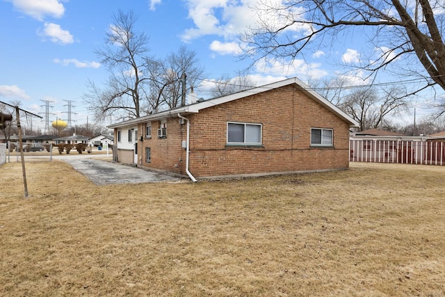 view of property exterior featuring a lawn and a patio