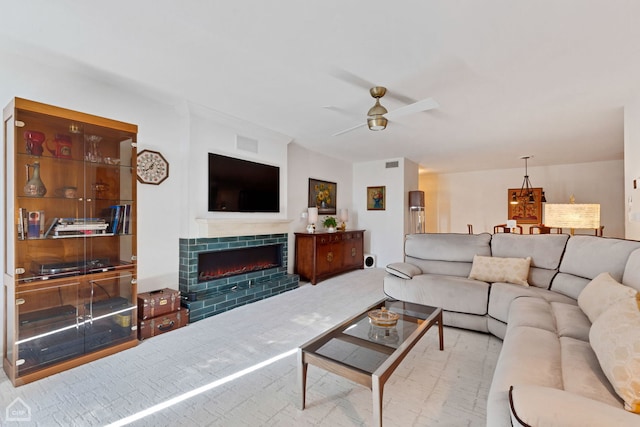 carpeted living room with a tile fireplace and ceiling fan