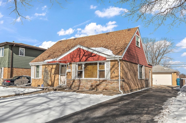 view of front of house with an outbuilding, stone siding, brick siding, and a garage