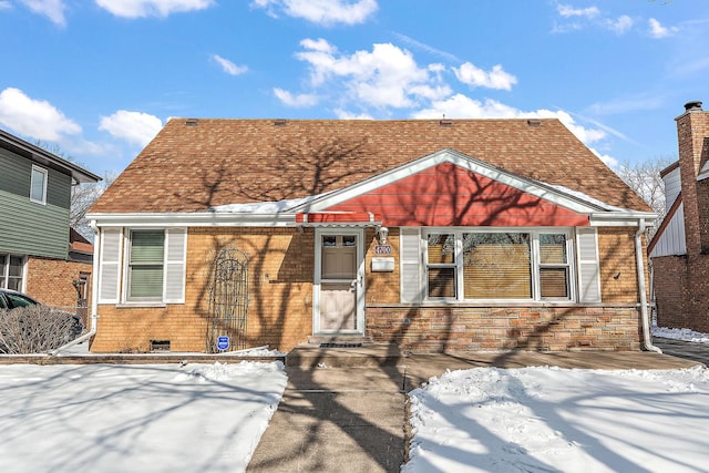 view of front of property featuring a shingled roof and brick siding