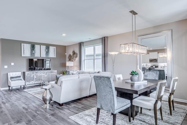 dining space with hardwood / wood-style flooring and a chandelier