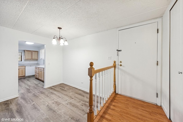 interior space with baseboards, an inviting chandelier, and light wood-style flooring