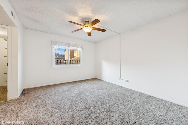 carpeted spare room featuring baseboards, visible vents, a textured ceiling, and ceiling fan