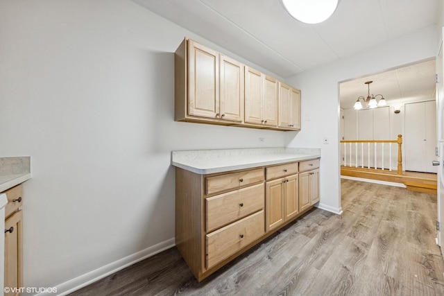 kitchen featuring light countertops, light wood-style flooring, light brown cabinets, and baseboards